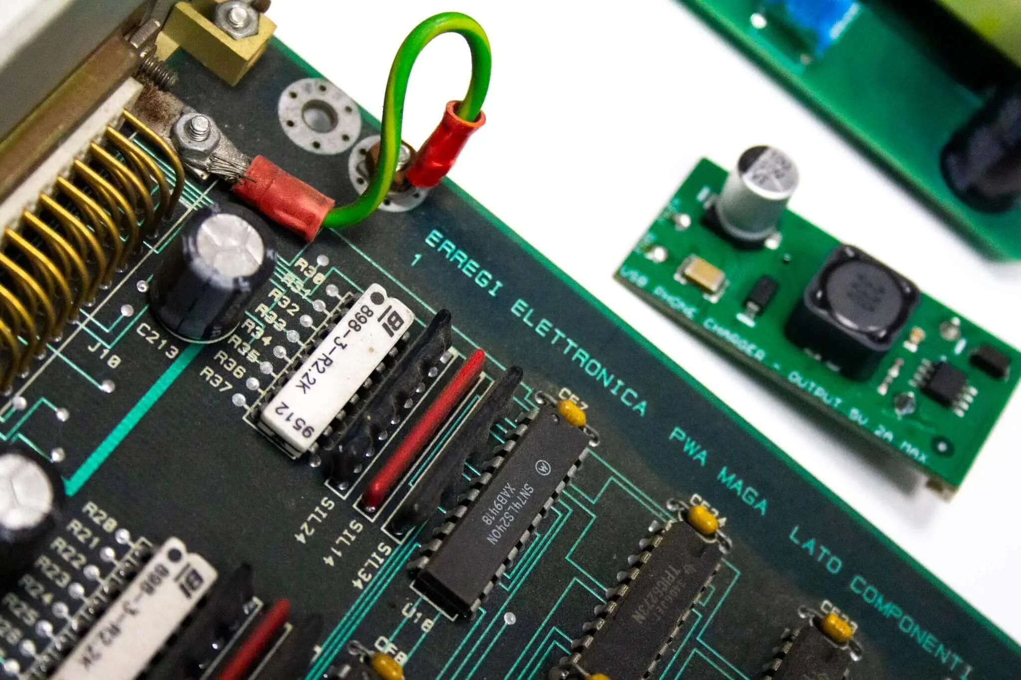 Dettaglio di una scheda ERREGI Elettronica accanto a un modulo di alimentazione